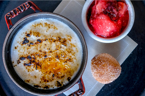 Baked rice pudding with cider, apple and bramble compote and cinnamon doughnut